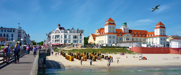 Von der Seebrücke in Binz öffnet sich der Blick über den hellen Strand. Dahinter liegt das Seebad mit ruhiger Ostseeluft.