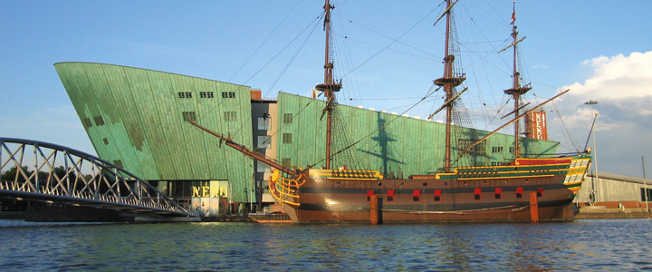 Im Marinemuseum Amsterdam treffen historische Schiffe auf die ruhige Kulisse des Hafens. Der Rheinraum wirkt weit und maritim geprägt.