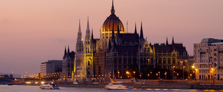 Das ungarische Parlament in Budapest leuchtet im Sonnenuntergang goldfarben. Die Donau spiegelt das warme Licht der untergehenden Sonne.